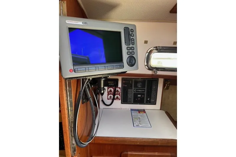 Slide: The Image of Navigation equipment inside a 1991 Caliber 33 sailboat, featuring control panels and a monitor. - 54