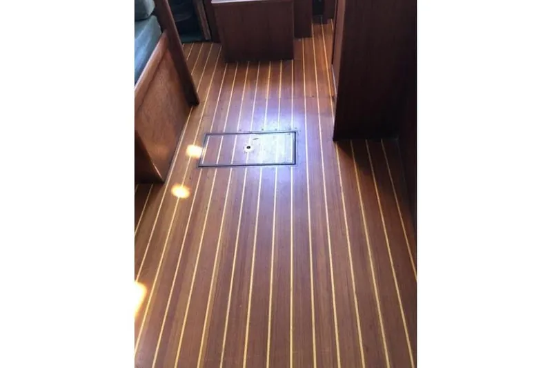Slide: The Image of Teak wood flooring inside a 1991 Caliber 33 boat cabin. - 55