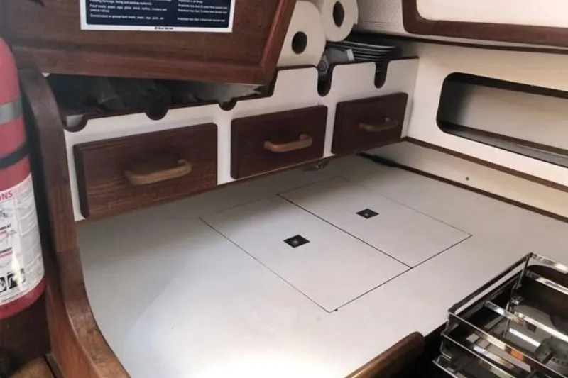 Slide: The Image of 1991 Caliber 33 yacht interior with wooden drawers and fire extinguisher. - 58