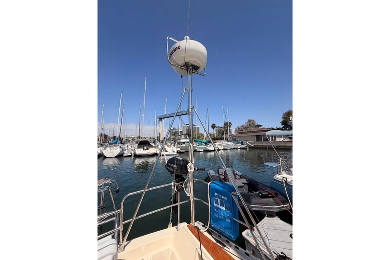 Slide: The Image of 1991 Caliber 33 sailboat docked in a marina, surrounded by other boats under a clear blue sky. - 17