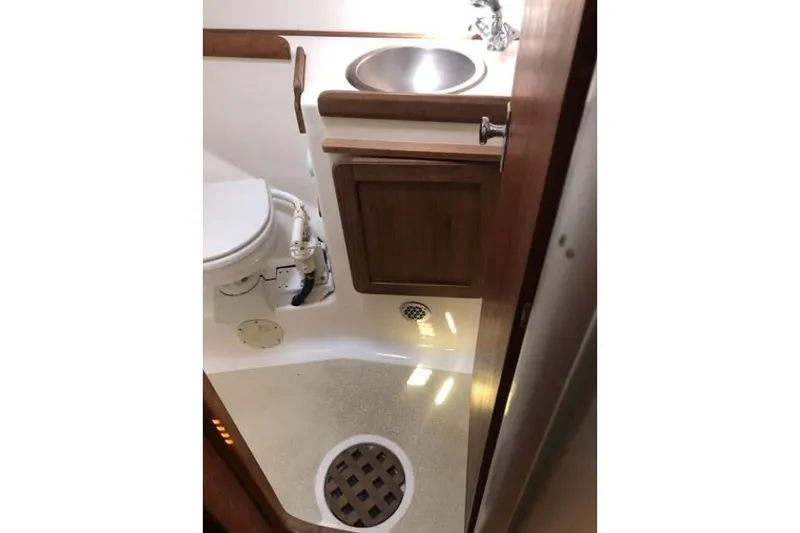Slide: The Image of 1991 Caliber 33 yacht bathroom with sink, toilet, and wooden cabinetry. - 67