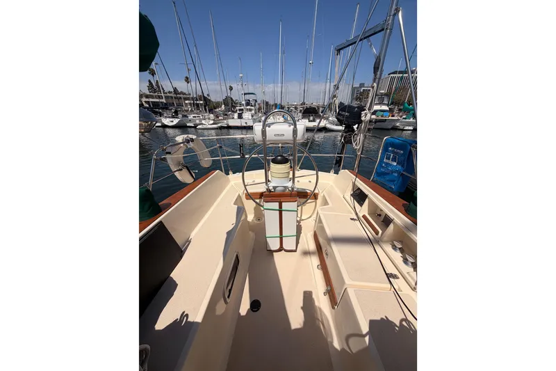 Slide: The Image of 1991 Caliber 33 sailboat cockpit with steering wheel, docked in a marina. - 16