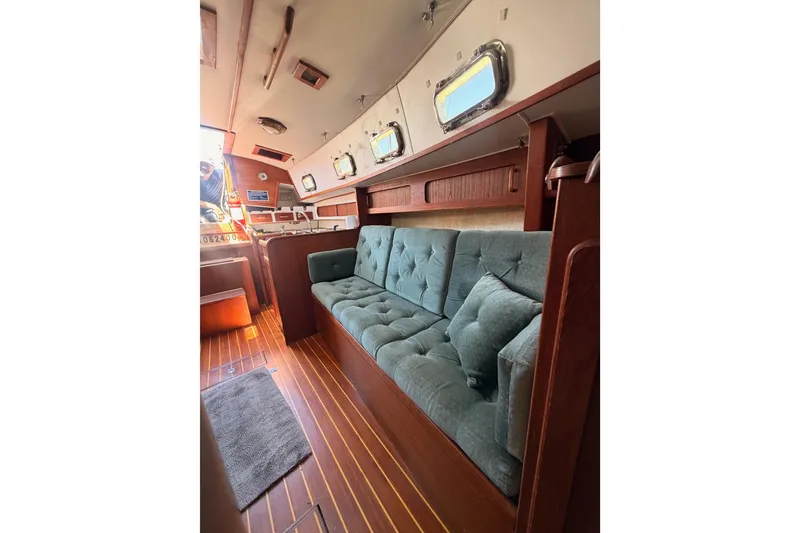 Slide: The Image of Interior of 1991 Caliber 33 sailboat with teal sofa and wooden accents. - 46