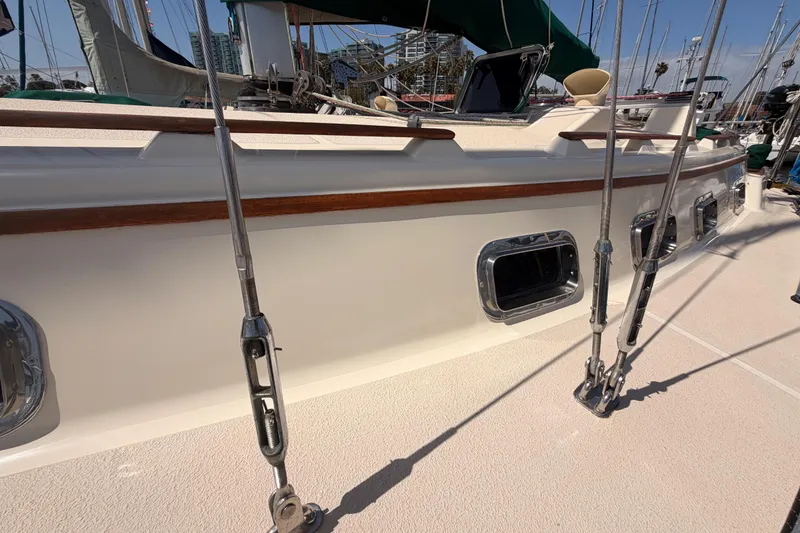 Slide: The Image of Sailboat deck of 1991 Caliber 33, featuring rigging and portholes in a marina setting. - 12