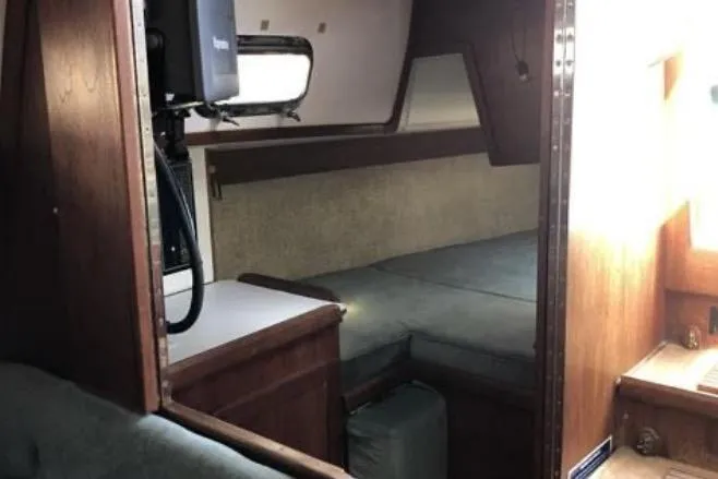 Slide: The Image of Interior of a 1991 Caliber 33 sailboat, featuring a cozy cabin with wooden furnishings. - 71