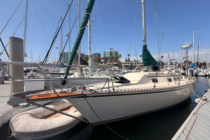 The Image of Sailboat docked at marina, 1991 Caliber 33 model, clear sky, urban backdrop. - 0