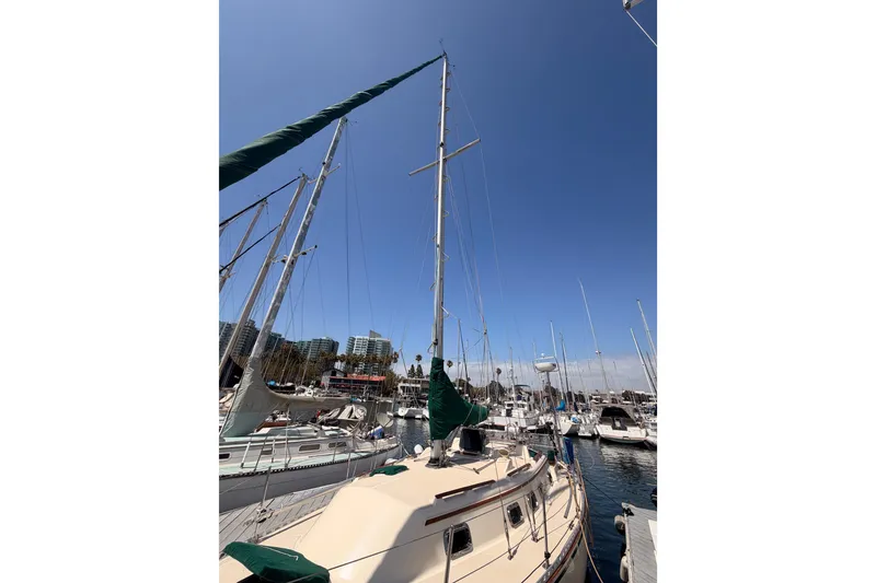 Slide: The Image of Sailboat docked in marina, Caliber 33 model, 1991, under clear blue sky. - 9