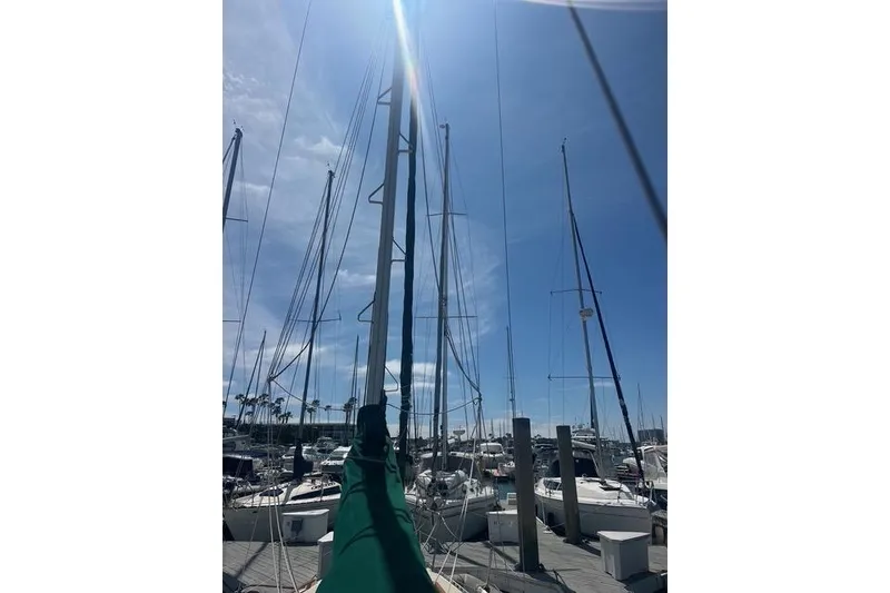 Slide: The Image of Sailboats docked under a clear blue sky, featuring a 1991 Caliber 33. - 9