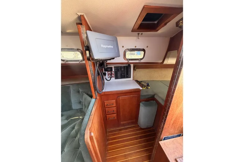 Slide: The Image of Interior of a 1991 Caliber 33 sailboat featuring navigation equipment and wooden cabinetry. - 34