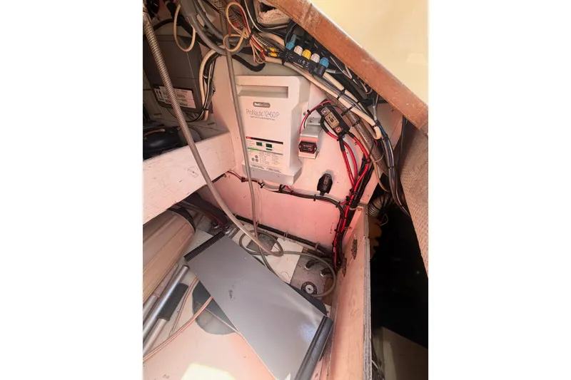 Slide: The Image of Electrical setup inside a 1991 Caliber 33 boat, featuring wiring and a ProNautic charger. - 28