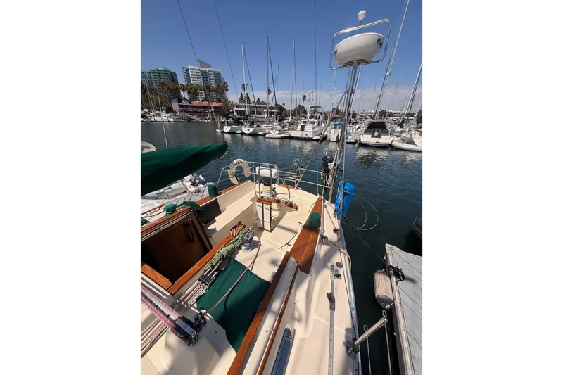 Slide: The Image of Sailboat docked in marina, Caliber 33 model, 1991, with clear blue sky and surrounding boats. - 15