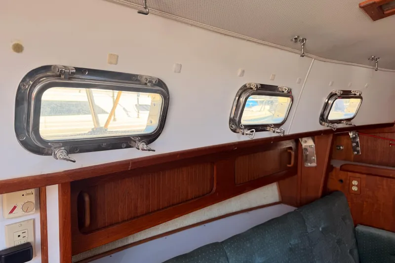 Slide: The Image of Interior of 1991 Caliber 33 sailboat with portholes and wooden cabinetry. - 39