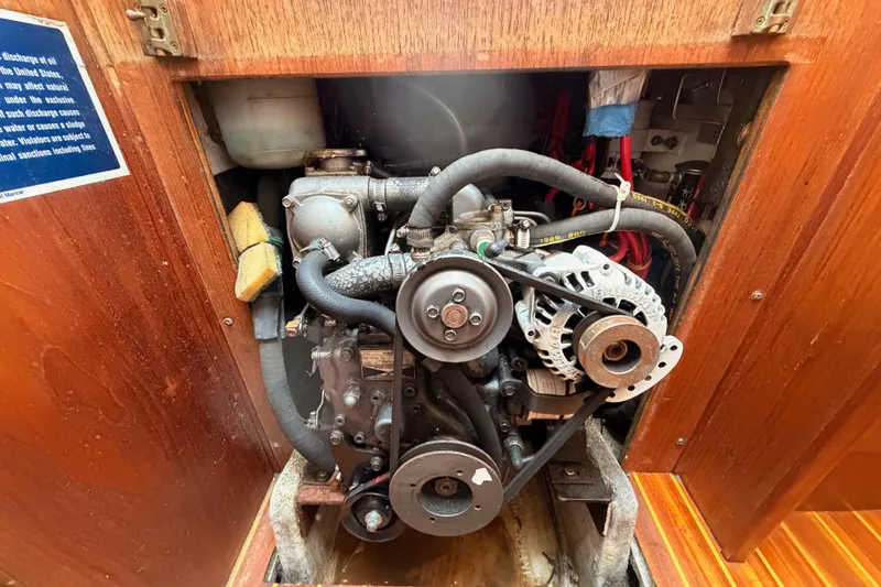 Slide: The Image of Engine compartment of a 1991 Caliber 33 sailboat, showcasing mechanical components and wiring. - 49