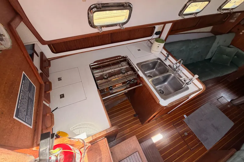 Slide: The Image of Interior of a 1991 Caliber 33 sailboat featuring a compact kitchen with dual sinks. - 31
