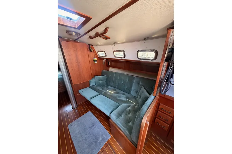 Slide: The Image of Interior of 1991 Caliber 33 sailboat with wooden paneling and blue cushioned seating. - 37