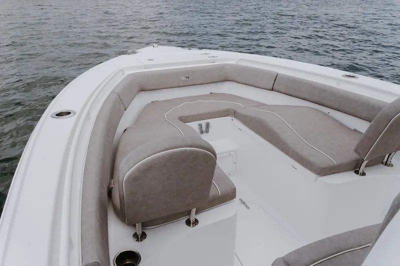 Slide: The Image of 2024 Sea Hunt Ultra 255 SE boat with spacious seating on calm water. - 12