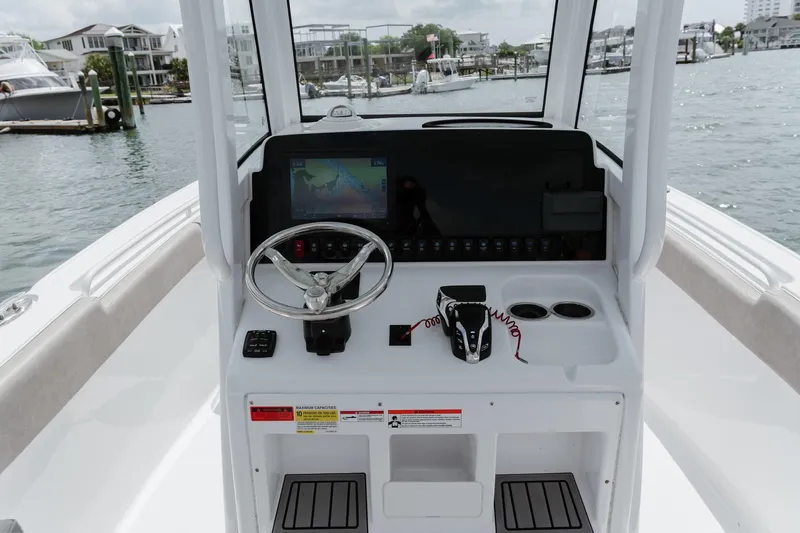 Slide: The Image of 2024 Sea Hunt Ultra 255 SE boat dashboard with steering wheel and navigation display. - 8