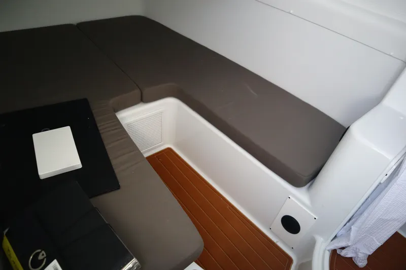 Slide: The Image of 2022 Yellowfin 42 Offshore cabin interior with cushioned seating and wooden flooring. - 19