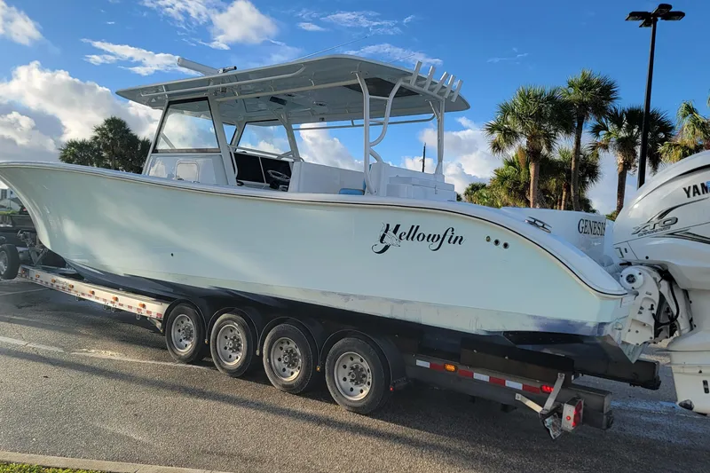 Slide: The Image of 2022 Yellowfin 42 Offshore boat on trailer, parked under a clear blue sky. - 2