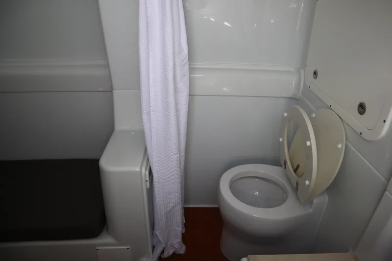 Slide: The Image of 2022 Yellowfin 42 Offshore boat bathroom with toilet and shower curtain. - 20