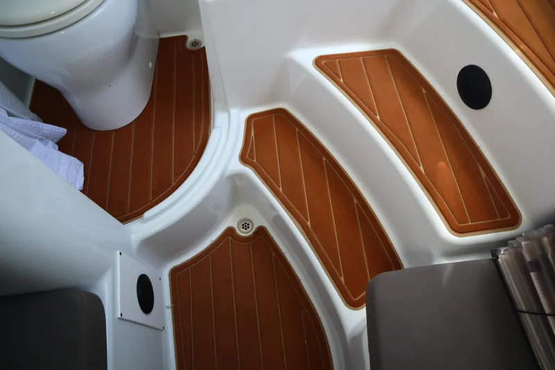 Slide: The Image of 2022 Yellowfin 42 Offshore boat interior with teak-style flooring and compact toilet. - 27