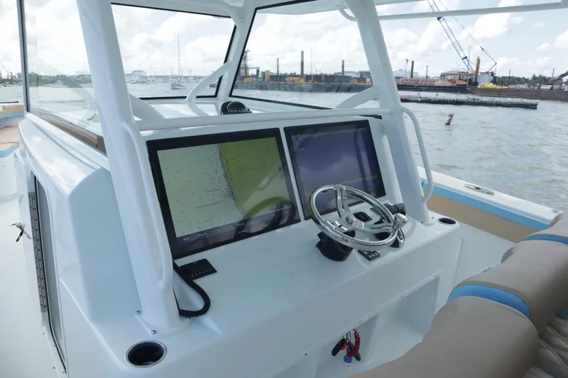 Slide: The Image of 2022 Yellowfin 42 Offshore boat dashboard with dual screens and steering wheel. - 31