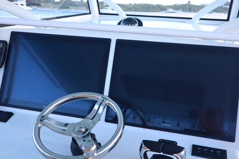 Slide: The Image of 2022 Yellowfin 42 Offshore helm with dual Garmin displays and steering wheel. - 42