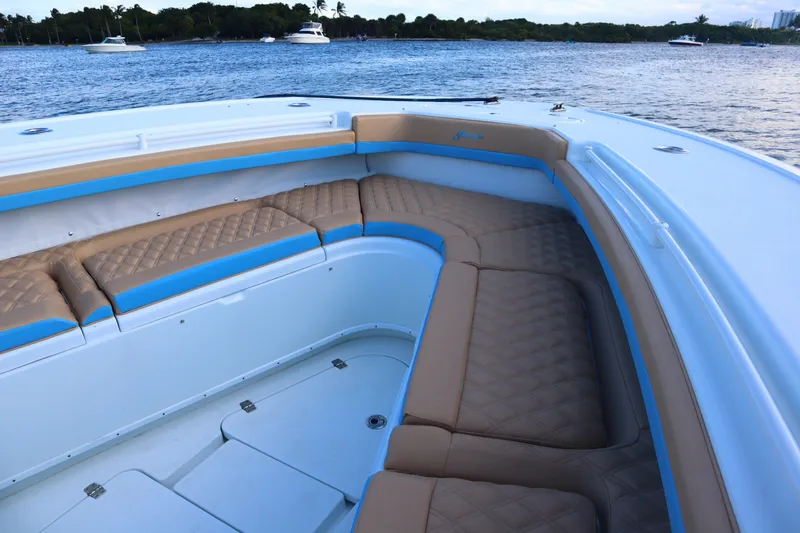 Slide: The Image of 2022 Yellowfin 42 Offshore boat with tan and blue seating, docked on calm water. - 44