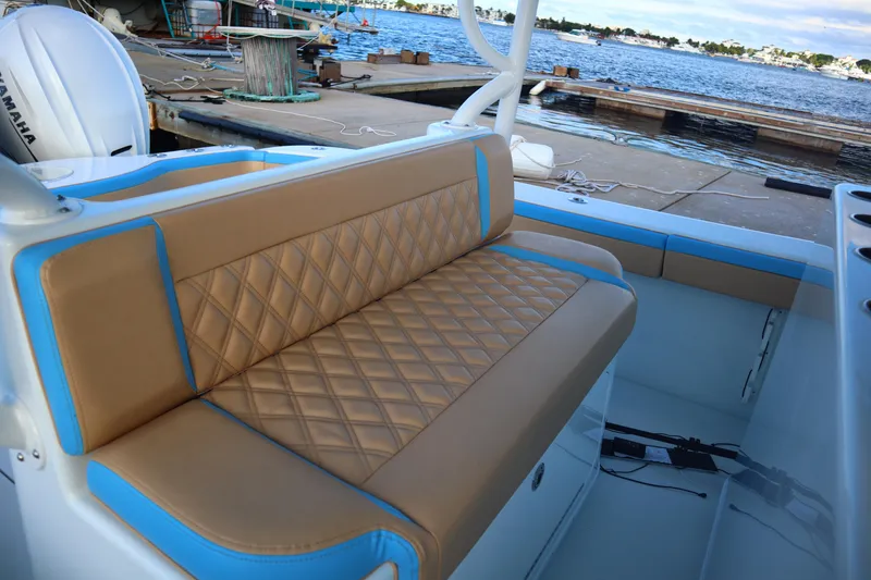 Slide: The Image of 2022 Yellowfin 42 Offshore boat with tan and blue seating by the dock. - 51