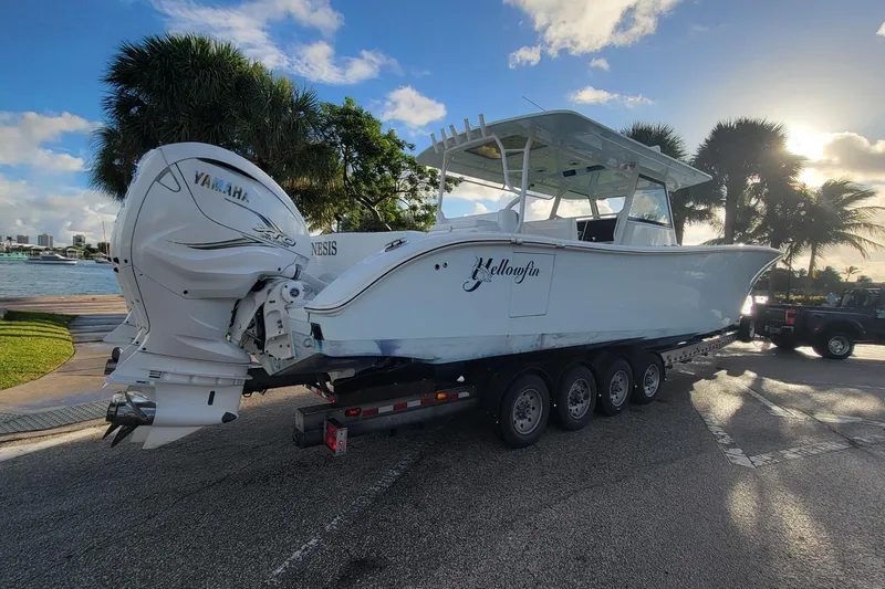 Slide: The Image of 2022 Yellowfin 42 Offshore boat on trailer with Yamaha engines, parked near waterfront. - 9