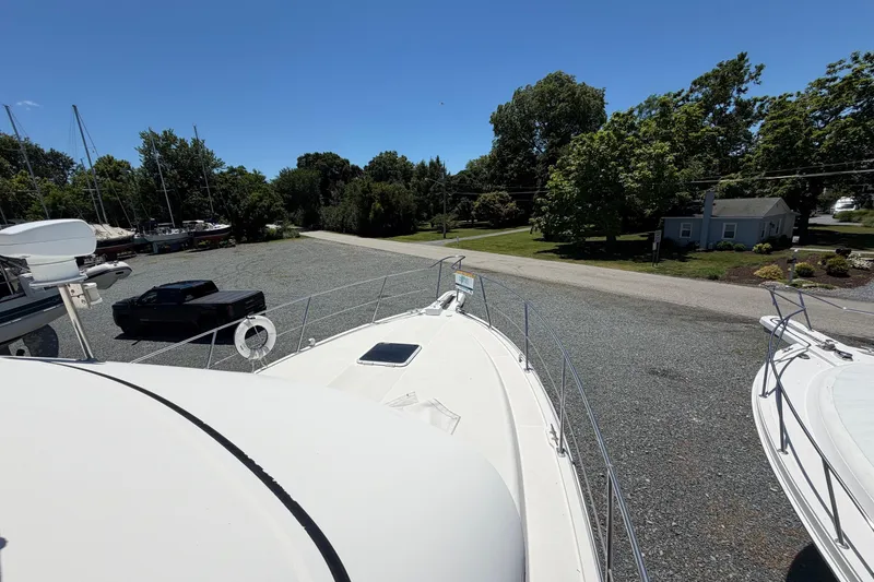 Slide: The Image of 1995 Carver 356 Aft Cabin Motor Yacht on gravel lot, surrounded by trees and parked vehicles. - 10