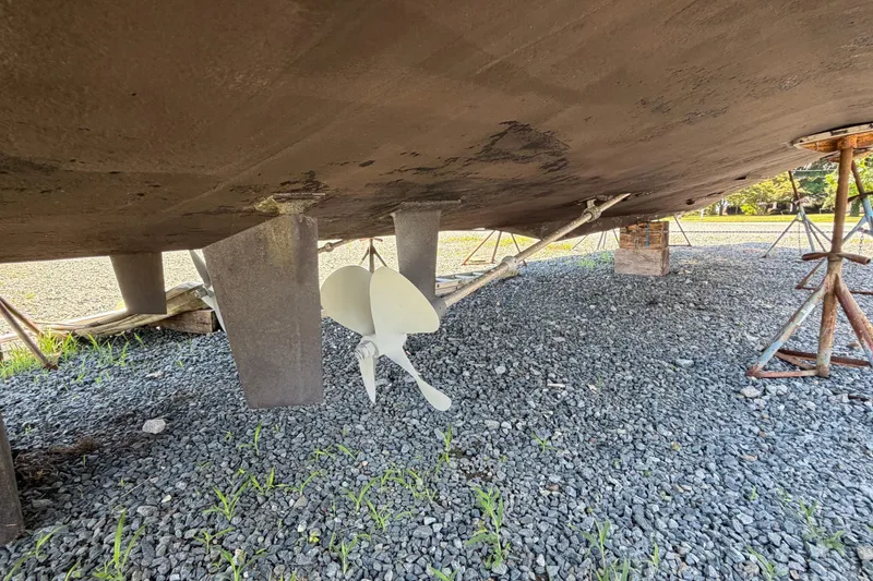 Slide: The Image of Underneath view of a 1995 Carver 356 Aft Cabin Motor Yacht on gravel. - 13