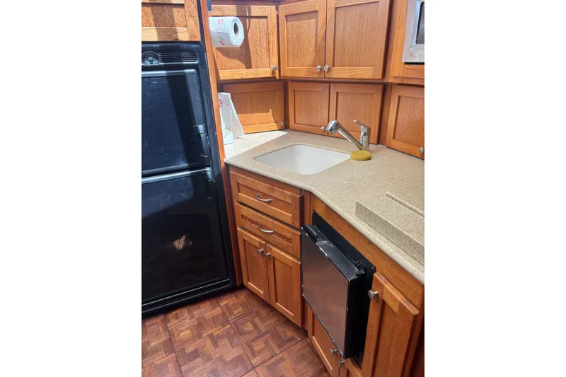 Slide: The Image of 1995 Carver 356 Aft Cabin Motor Yacht kitchen with wooden cabinets and modern appliances. - 17