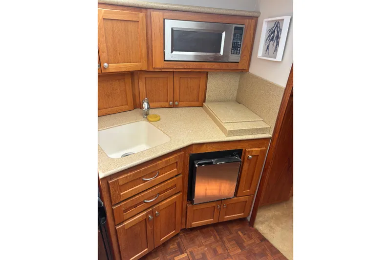 Slide: The Image of 1995 Carver 356 Aft Cabin Motor Yacht kitchen with wood cabinets and modern appliances. - 18