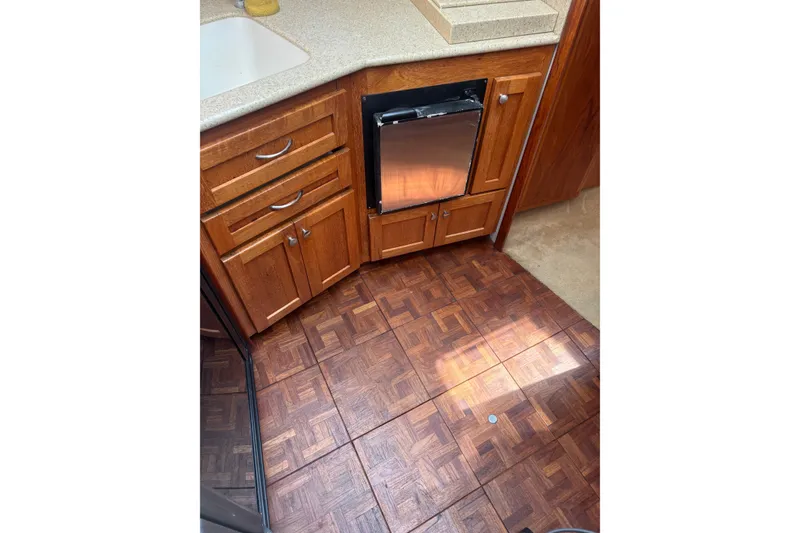 Slide: The Image of 1995 Carver 356 Aft Cabin Motor Yacht kitchen with wood cabinets and parquet flooring. - 19