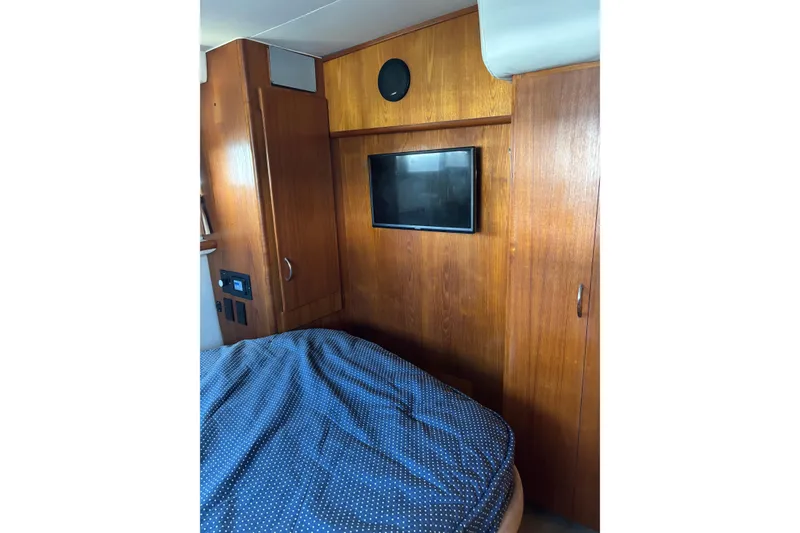 Slide: The Image of Interior of 1995 Carver 356 Aft Cabin Motor Yacht with wood paneling and TV. - 22