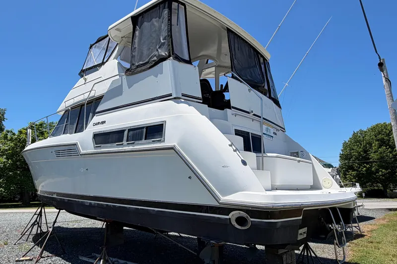 Slide: The Image of 1995 Carver 356 Aft Cabin Motor Yacht on stands, exterior view under clear blue sky. - 6