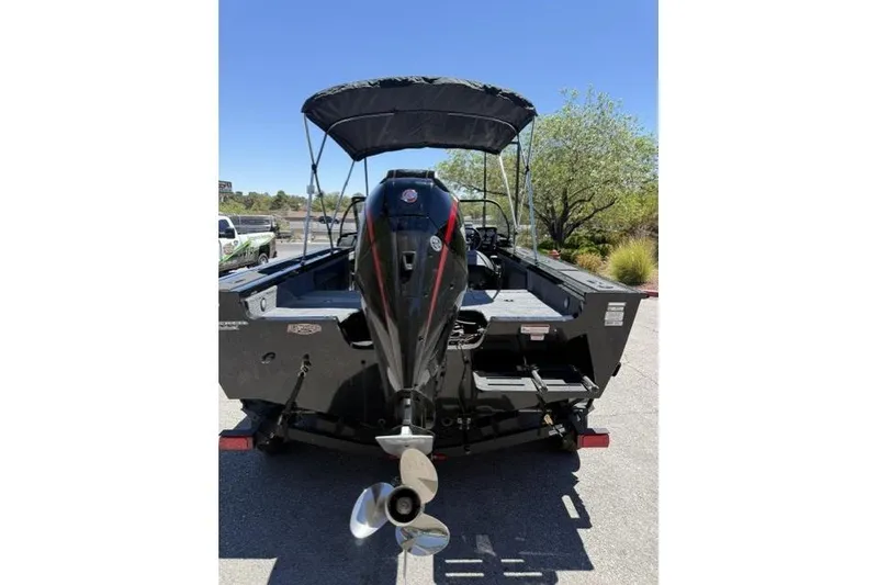 Slide: The Image of 2026 Tracker Targa V-19 Combo boat with outboard motor and canopy, parked outdoors. - 5