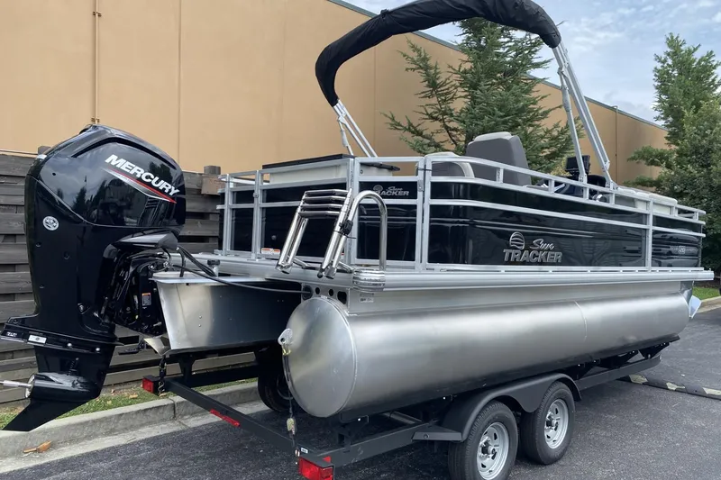 Slide: The Image of 2026 Sun Tracker Fishin' Barge 20 DLX pontoon boat with Mercury outboard motor on trailer. - 1