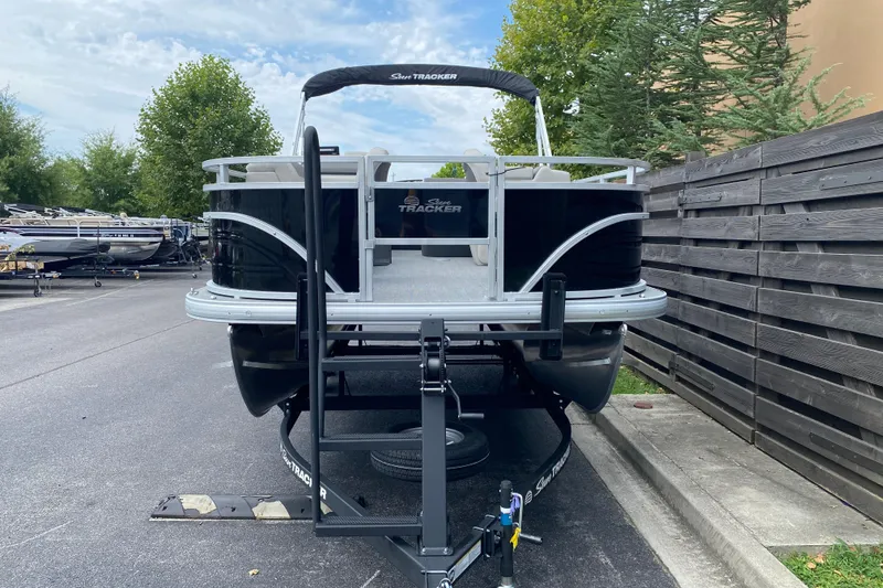 Slide: The Image of 2026 Sun Tracker Fishin' Barge 20 DLX pontoon boat on trailer, parked outdoors. - 3