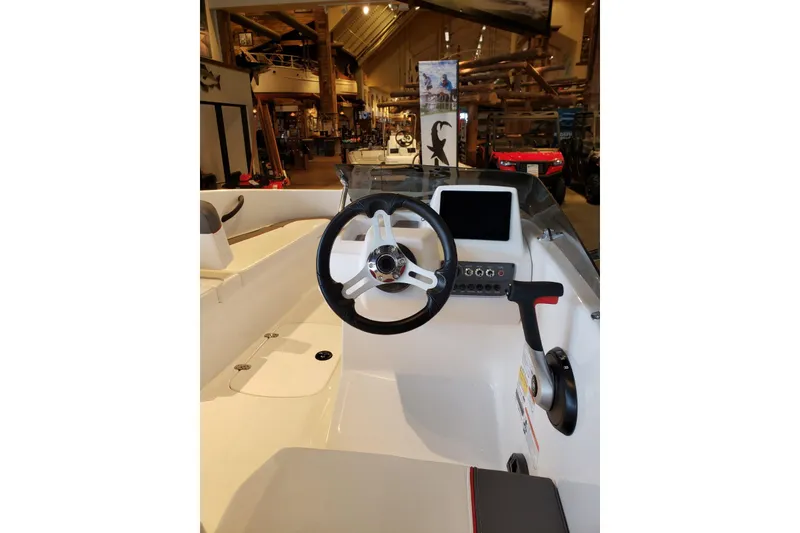 Slide: The Image of 2026 Tahoe T16 boat interior with steering wheel and control panel in showroom. - 7