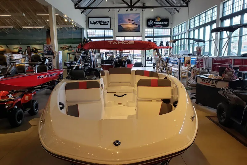 Slide: The Image of 2026 Tahoe T16 boat displayed in a showroom with various marine equipment. - 2