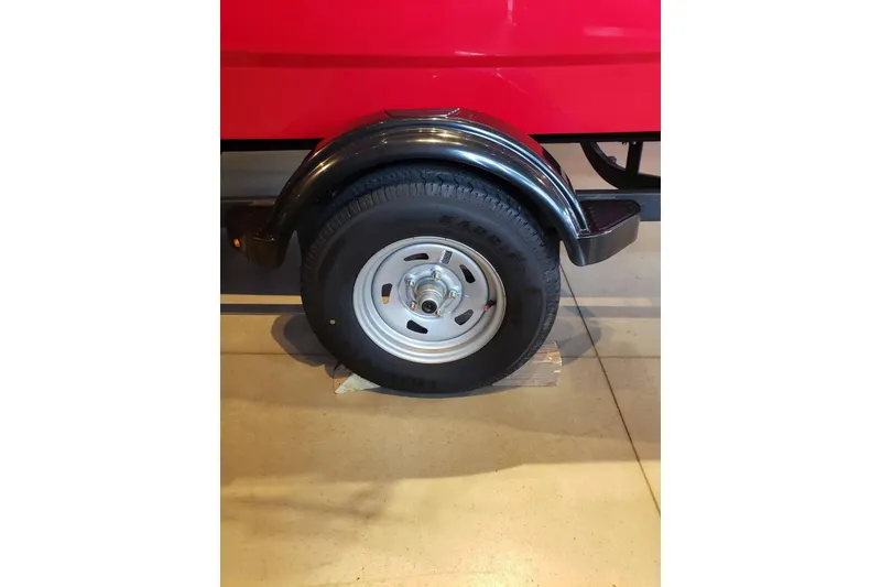 Slide: The Image of 2026 Tahoe T16 trailer wheel with black fender on display indoors. - 6