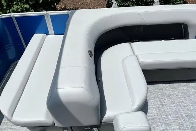 Slide: The Image of 2026 Sun Tracker Party Barge 18 DLX with white cushioned seating and blue paneling. - 11