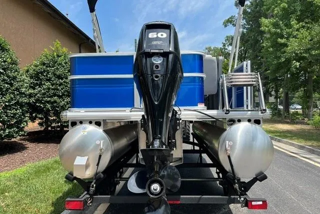 Slide: The Image of 2026 Sun Tracker Party Barge 18 DLX pontoon boat with 60 HP engine, parked outdoors. - 4