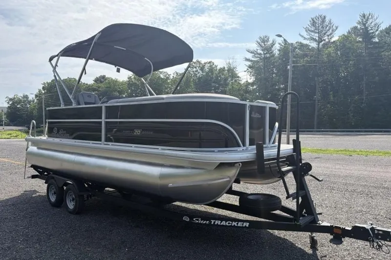 Slide: The Image of 2026 Sun Tracker Party Barge 20 DLX pontoon boat on trailer, parked outdoors. - 3