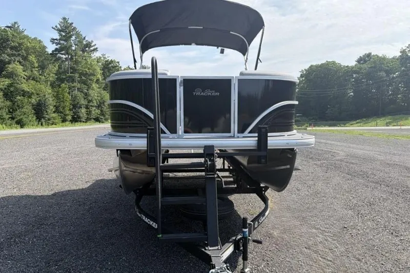 Slide: The Image of 2026 Sun Tracker Party Barge 20 DLX pontoon boat on trailer, parked outdoors. - 6