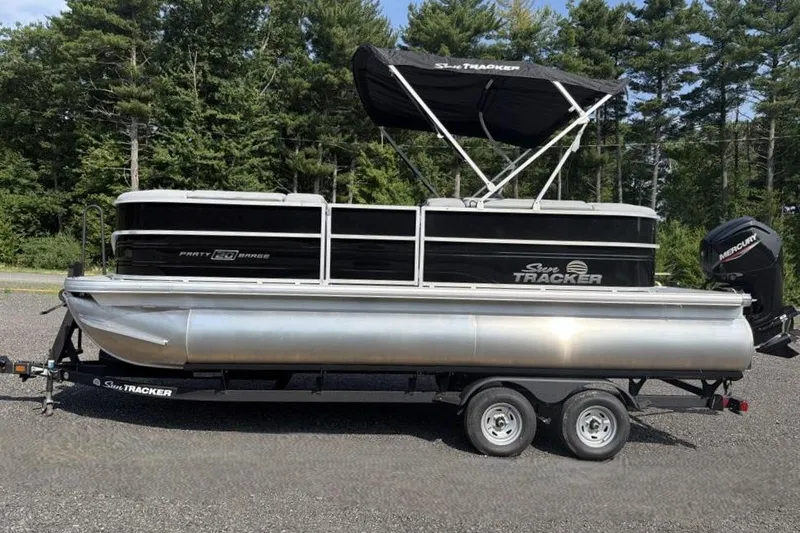 The Image of 2026 Sun Tracker Party Barge 20 DLX pontoon boat on trailer, parked outdoors. - 0