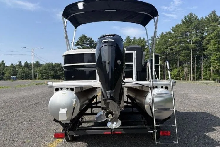 Slide: The Image of 2026 Sun Tracker Party Barge 20 DLX pontoon boat with canopy, parked on a trailer. - 7