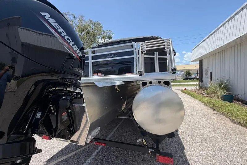 Slide: The Image of 2026 Sun Tracker Sportfish 24 XP3 pontoon boat with Mercury engine, parked outdoors. - 96
